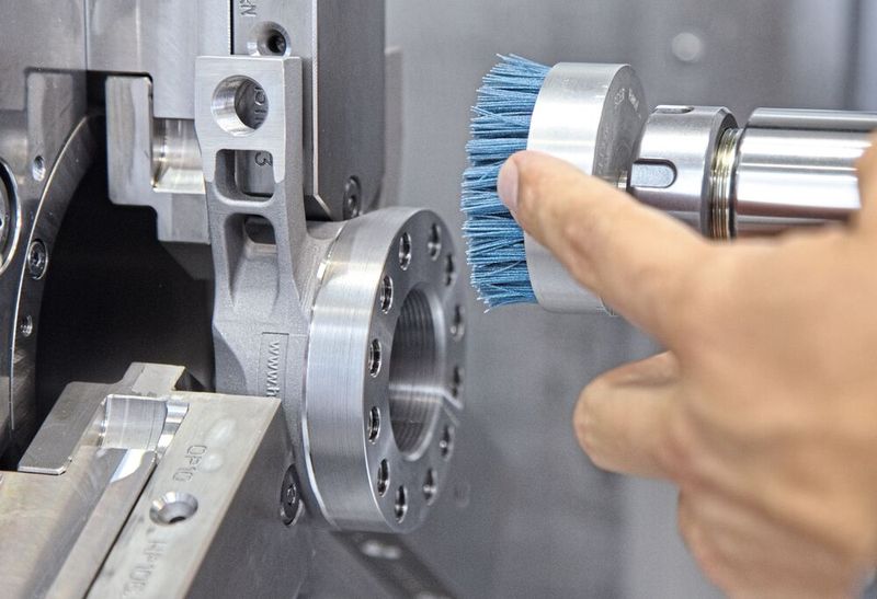 Seit Ende 2024 wird in der Produktion der Herzog Systems AG auf Bürsttechnologie gesetzt, um Komponenten auf CNC-Bearbeitungszentren zu entgraten. Damit konnte auf einem flexiblen Fertigungssystem eine voll autonome Fertigung inklusive 3D-Vermessung realisiert werden. Im Bild eine Zeintra-Schafttopfbürste mit auf das Bauteil und den Werkstoff abgestimmten Filament (blau).  (Bild: Matthias Böhm)