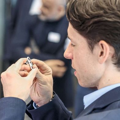 Ein Teilnehmer begutachtet die Laserbeschriftung eines medizinischen Bauteils. (Bild: Trumpf Schweiz AG)